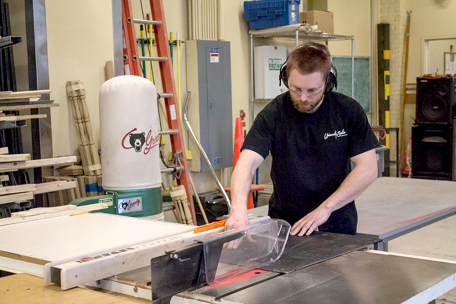 Student working on table saw in the Scene shop.